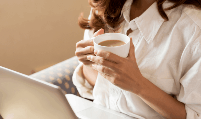 Young professional enjoying her morning coffee while connecting through virtual coffee chats from her home office.